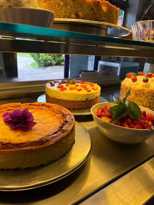 Käsekuchen mit essbarer Blüte in der Kuchenvitrine