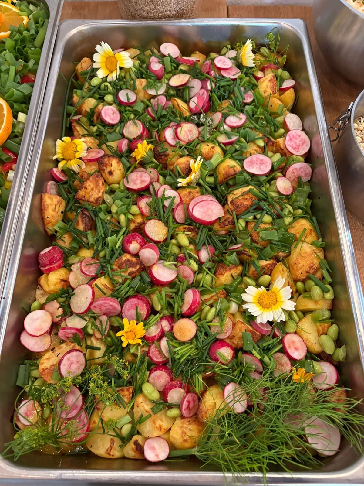 Große Platte mit Kartoffeln, Radieschen und Blüten für ein Buffet