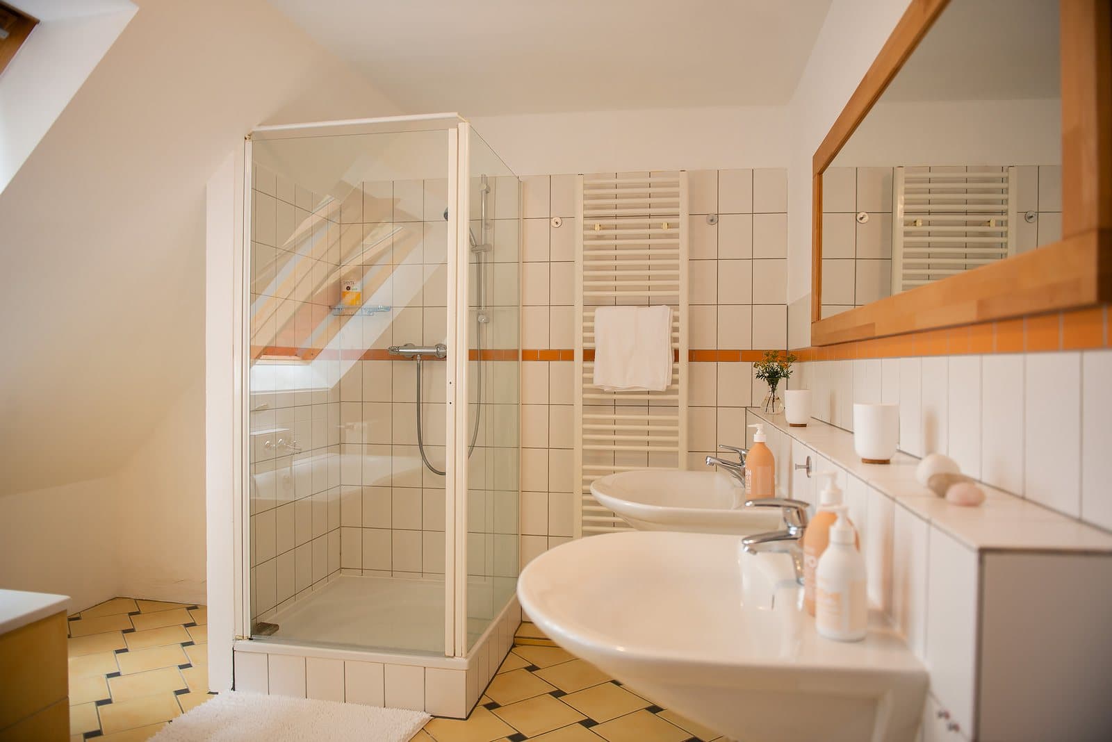 Badezimmer mit Dusche und zwei Waschbecken