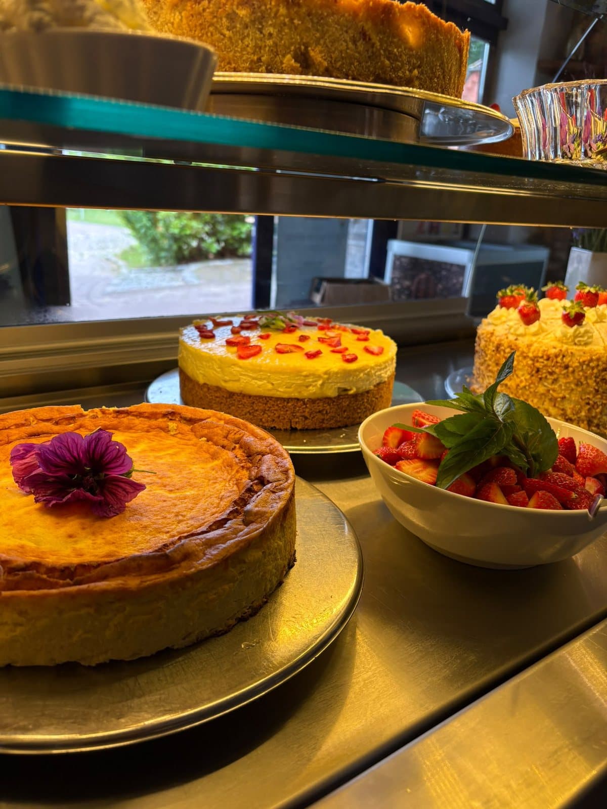 Käsekuchen mit essbarer Blüte in der Kuchenvitrine